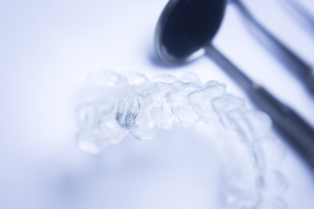Invisible teeth aligner cosmetic orthodontic brackets used to straighten and align teeth in patient with clear plastic see through aesthetic look.の写真素材
