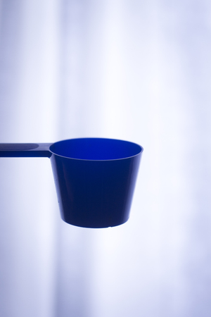 Protein isolated, concentrated and micro filtered whey and casein milk based powder sports protein supplement plastic container scoop.の写真素材