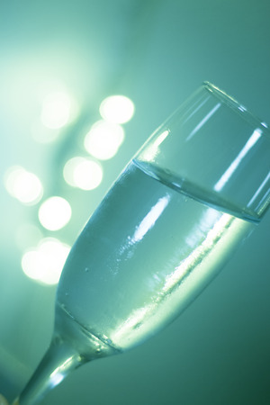 Champagne sparkling wine glass in disco party at night with defocused festive Christmas and New Year lights in nightclub.の写真素材
