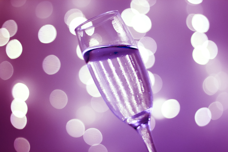 Champagne sparkling wine glass in disco party at night with defocused festive Christmas and New Year lights in nightclub.の写真素材