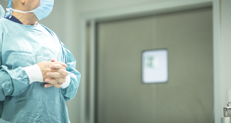 Surgeon in hospital surgery in sterile uniform "scrubs" in operating theater emergency room in surgical operation.の写真素材