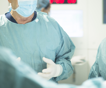 Surgeon in hospital surgery in sterile uniform "scrubs" in operating theater emergency room in surgical operation.の写真素材