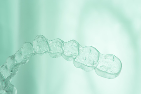 Invisible orthodontics cosmetic brackets tooth aligners plastic braces modern teeth retainers isolated closeup.の写真素材