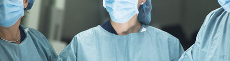 Surgeon in hospital surgery in sterile uniform "scrubs" in operating theater emergency room in surgical operation.の写真素材