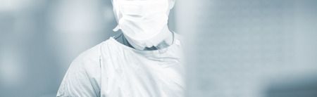 Surgeon in hospital surgery in sterile uniform "scrubs" in operating theater emergency room in surgical operation.の写真素材