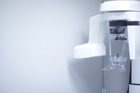 Dentist's office high technology modern dental xray machine in clinic to take x-rays of pateint teeth, mouth and jaw.の写真素材