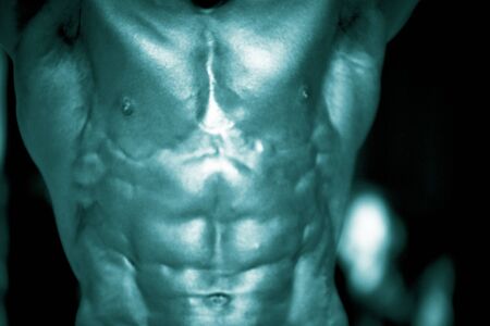 Bodybuilder muscular strong man flexing muscles shirtless in bodybuilding competition posing round.