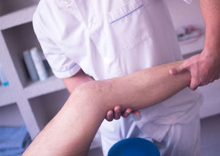 Physical therapy manual physiotherapy treatment by physiotherapist on patient for knee inury rehabilitation.の写真素材