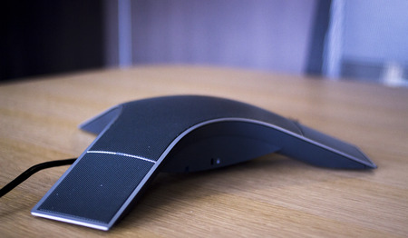 Conference call speaker telephone in luxury modern office table corporate company meeting room.の写真素材