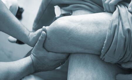 Physical therapy manual physiotherapy treatment by physiotherapist on patient for knee inury rehabilitation.の写真素材