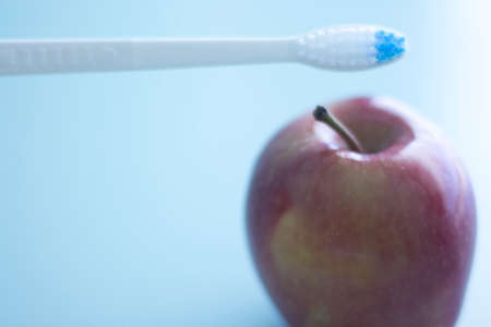 Dental toothbrush to clean teeth and fresh red apple for healthy eating.の写真素材