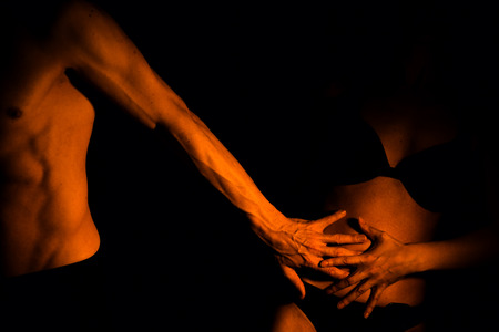 Sexy couple nude slim athletic man and erotic slender lady naked touching bodies in the dark.の写真素材