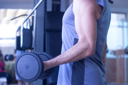 Middle aged man in 40's working out exercise fitness sports weights training in gym health studio.の写真素材