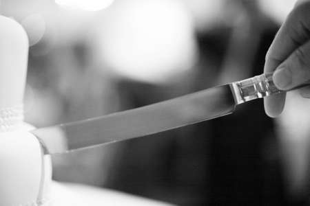 Wedding party evening marriage reception cake cutting ceremony cut with knife.の写真素材