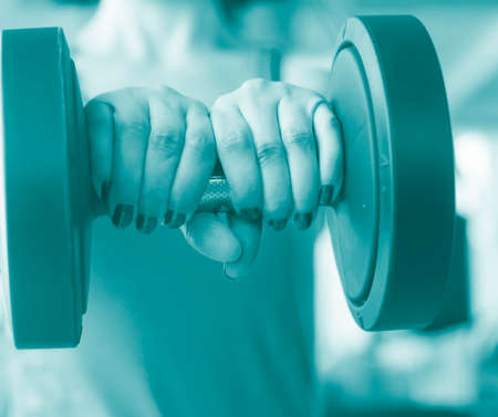 Woman working out female exercise fitness sports weights training in gym health studio.の写真素材