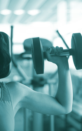 Woman working out female exercise fitness sports weights training in gym health studio.の写真素材