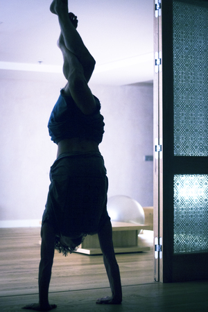 Male yoga teacher doing handstand inversion alisthenics and yoga asana practice in gym fitness...