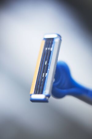 Modern safety disposable plastic shaving razor with multiple blades and moisturising strip.