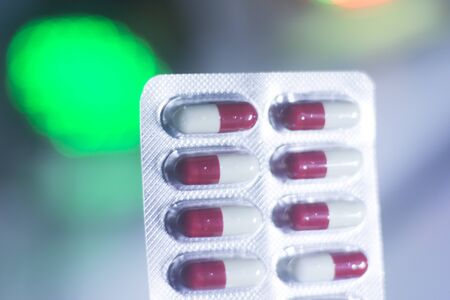 Medicine prescription drug pills blister pack isolated in red and white capsules.