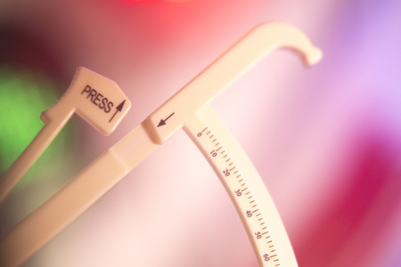 Weight loss diet fat calipers to measure bodyfat levels for healthy regime of fitness.の写真素材