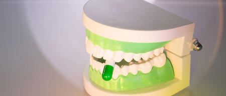 Dental teeth, mouth, gums dentists teaching model showing each tooth and medication drug pill.の写真素材