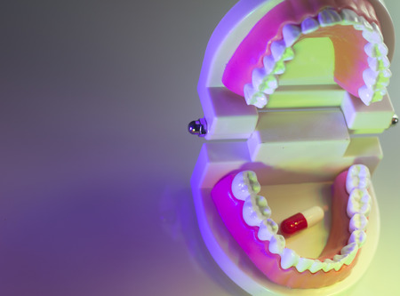 Dental teeth, mouth, gums dentists teaching model showing each tooth and medication drug pill.の写真素材