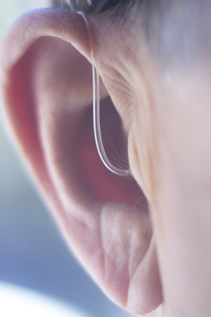 Modern digital in the ear hearing aid for deafness and the hard of hearing in aged man's ear.の写真素材