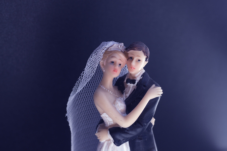 Bride and bridegroom wedding cake topper plastic statues holding after marriage ceremony.の写真素材