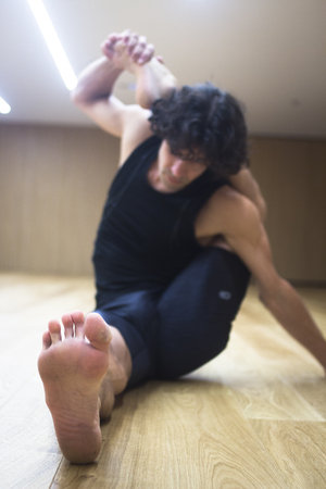 Man yoga teacher practising in gym fitness studio doing advanced asana posture.の写真素材