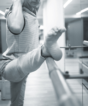 Man dancer dance  teacher stetching in gym fitness studio doing advanced bar stretch flexibility posture.の写真素材