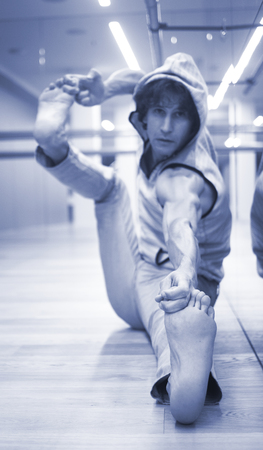 Man dancer dance  teacher stetching in gym fitness studio doing advanced bar stretch flexibility posture.の写真素材