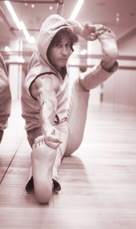 Man dancer dance  teacher stetching in gym fitness studio doing advanced bar stretch flexibility posture.の写真素材