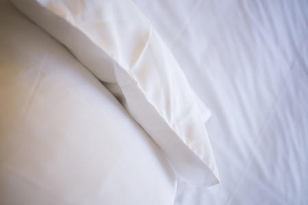 Luxury hotel bedroom bed clean ironed tidy cotton sheets and pillows ready for guests to sleep.の写真素材