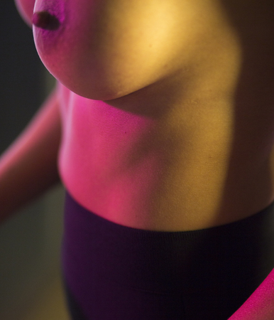 Sexy busty big breasts semi nude erotic young lady with beautiful attractive body at night in flat.の写真素材