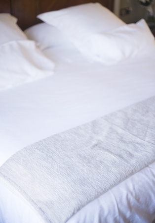 Luxury hotel bedroom bed clean ironed tidy cotton sheets and pillows ready for guests to sleep.の写真素材