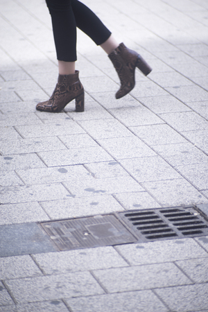 People walking in busy urban city shopping street sidewalk pavement shoes feet and legs.の写真素材
