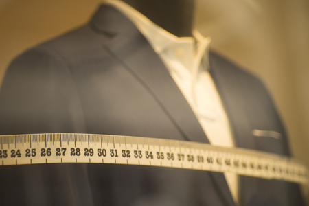 Tailor's shop window made to measure tailored suit store mannequin with formal shirt and tie with measuring tape.の写真素材