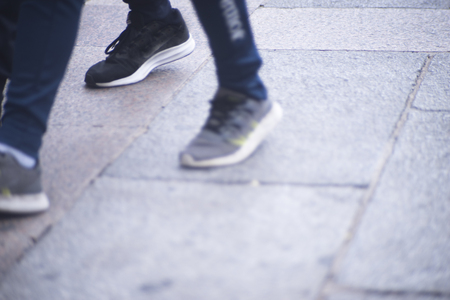 People walking in busy urban city shopping street sidewalk pavement shoes feet and legs.の写真素材