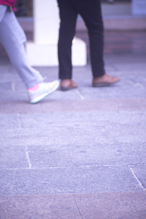 People walking in busy urban city shopping street sidewalk pavement shoes feet and legs.の写真素材