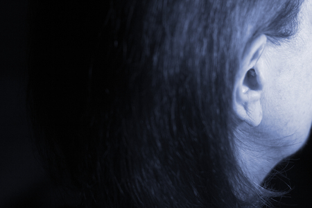 Deaf senior citizen lady wearing modern digital high technology hearing aid in ear.の写真素材
