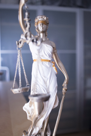 Law office legal justice statue of blind goddess Themis with scales in lawyers office.の写真素材