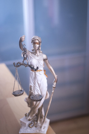Law office legal justice statue of blind goddess Themis with scales in lawyers office.の写真素材