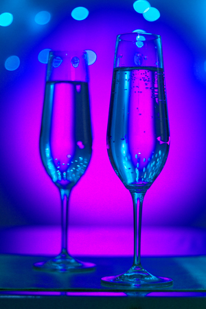Champagne sparkling wine glasses of prosecco cava in nightclub party bar during wedding in Ibiza Spain with lights behind.の写真素材