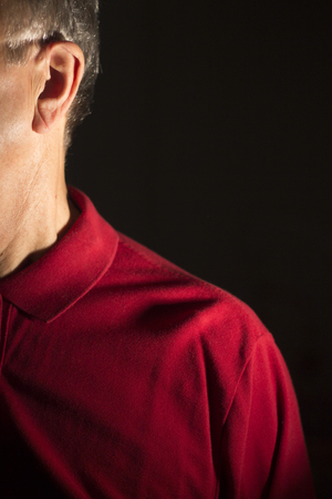 Deaf senior citizen man wearing modern digital high technology hearing aid in ear.の写真素材