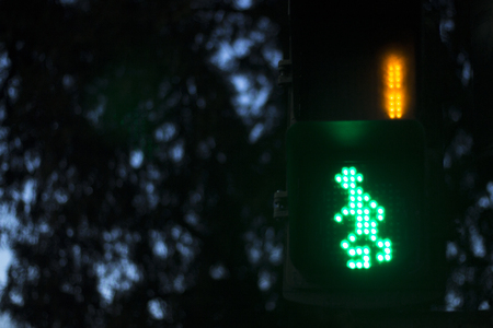 Zebra pedestrian crossing street traffic light for pedestrians to cross road with green man and seconds remaining.の写真素材