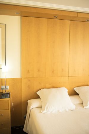 Luxury modern style hotel suite bedroom with bed, sheets, pillows clean and ready for guests.の写真素材