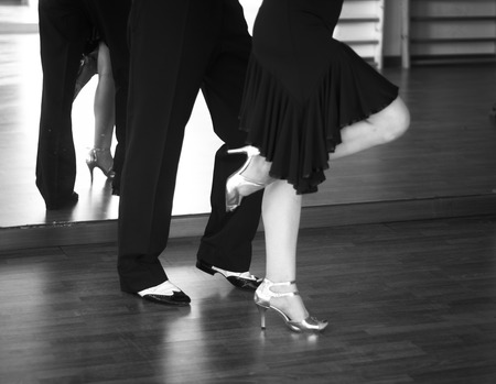 Ballroom dance salsa dancer instructors man and woman couple dancing in shcool rehearsal roomの写真素材