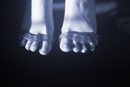 Young woman with silicone toe separator to separate toes to pedicure and paint or file toenails.の写真素材