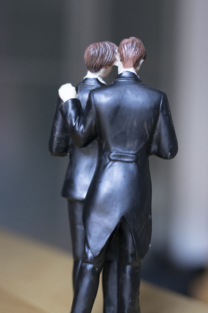 Cake topper gay wedding couple of two male grooms holding romantic marriage embrace of LGBT love.の写真素材