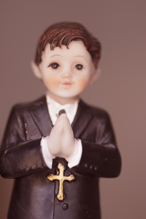Cake topper Catholic holy communion ceremony religious boy praying to Christian God in church.の写真素材